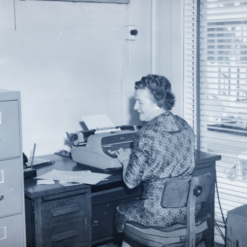 historic image of woman using typewriter circa 1960s